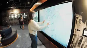 Honoring History: Exhibit Studios' Remarkable Civil War Battle Flag Exhibit Exhibit Studios Using two hands for large gestures on multi touch screen with civil war map.