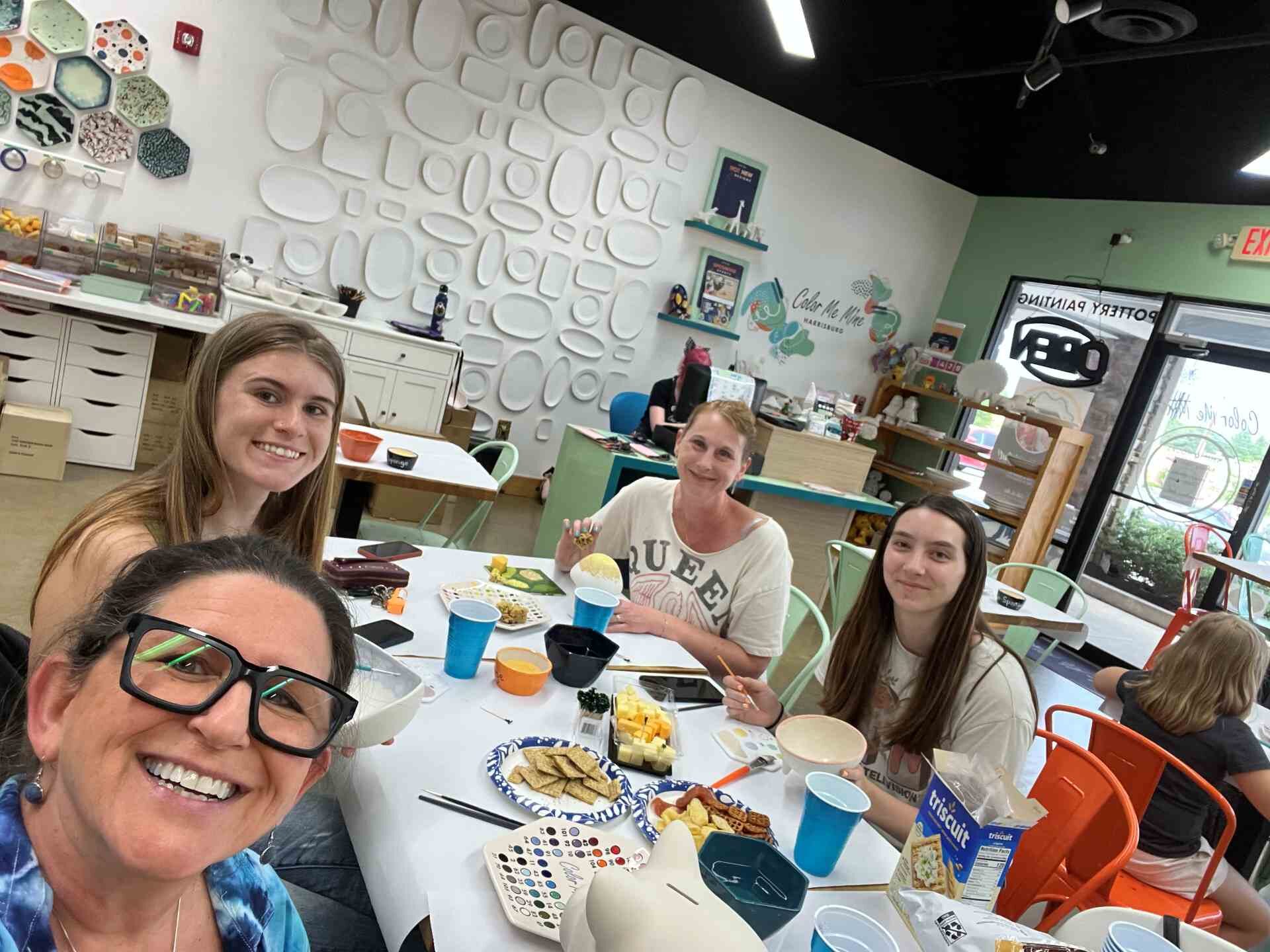 employees painting together around a table