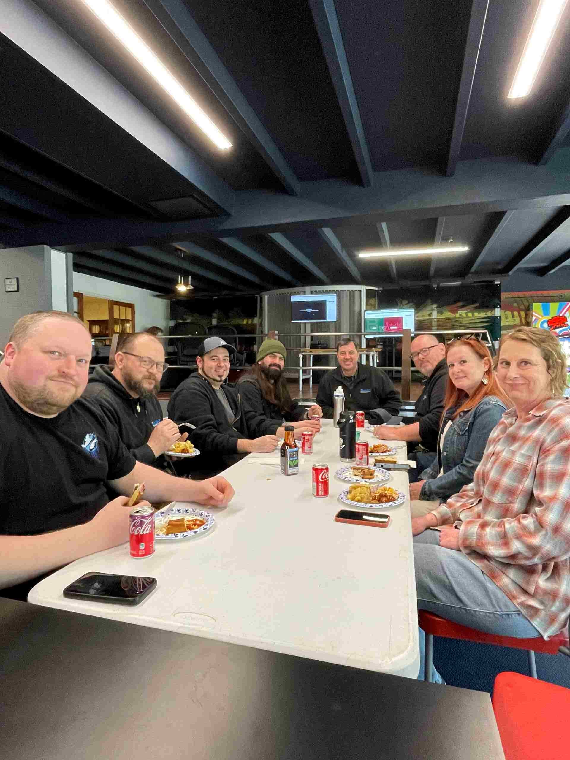 employees gathered around a table for a company celebration