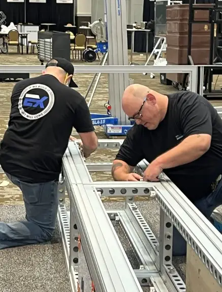 Exhibit Studios employees working on a trade show booth