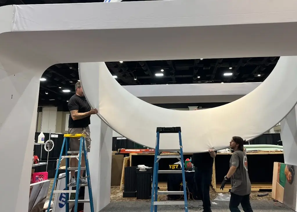 Exhibit Studios employees working on a trade show project to show an example of a trade show partner