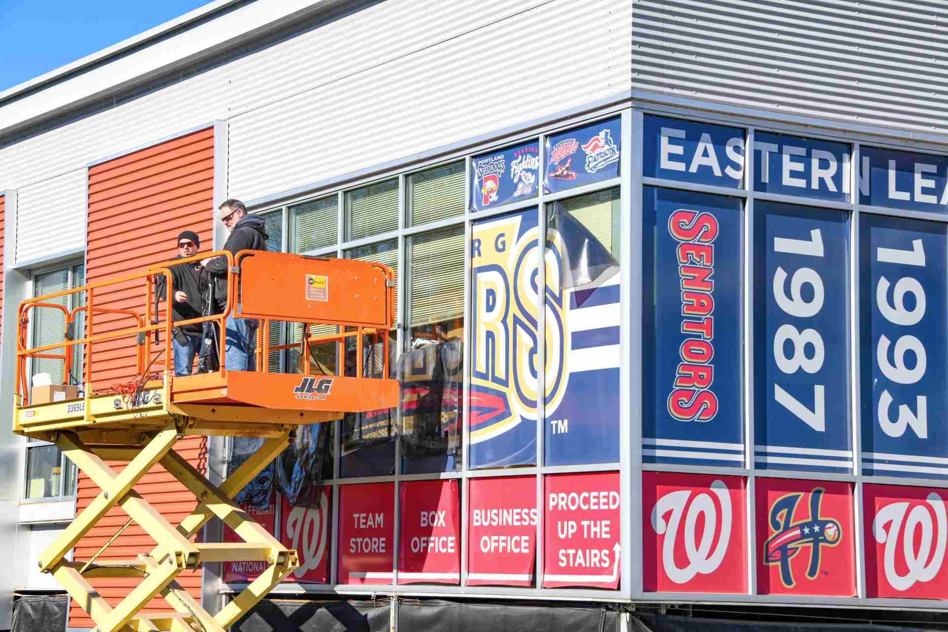 Exhibit Studios employee installing large format window graphics for the Harrisburg Senators