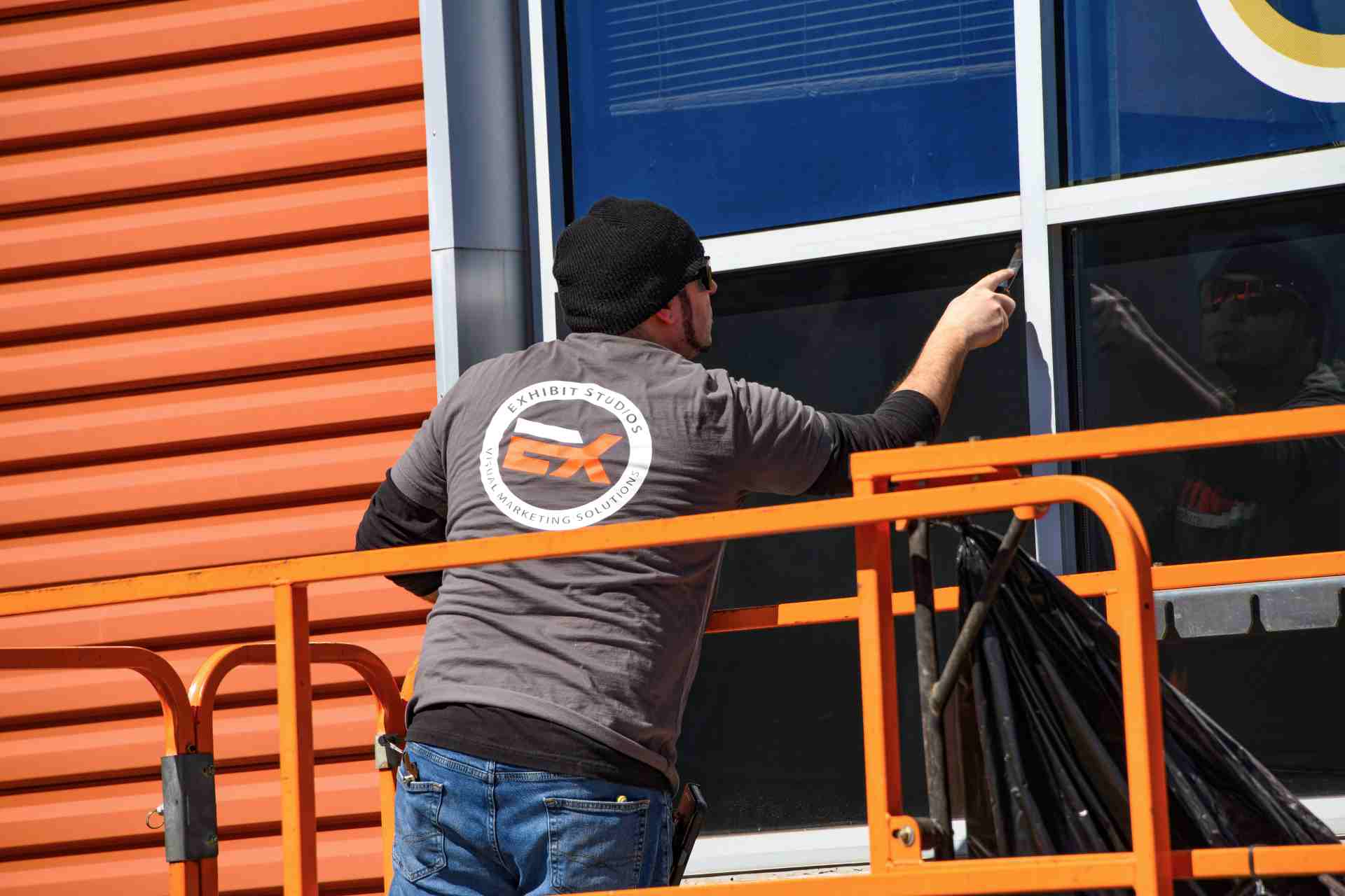 Exhibit Studios employee installing large format window graphics for the Senators